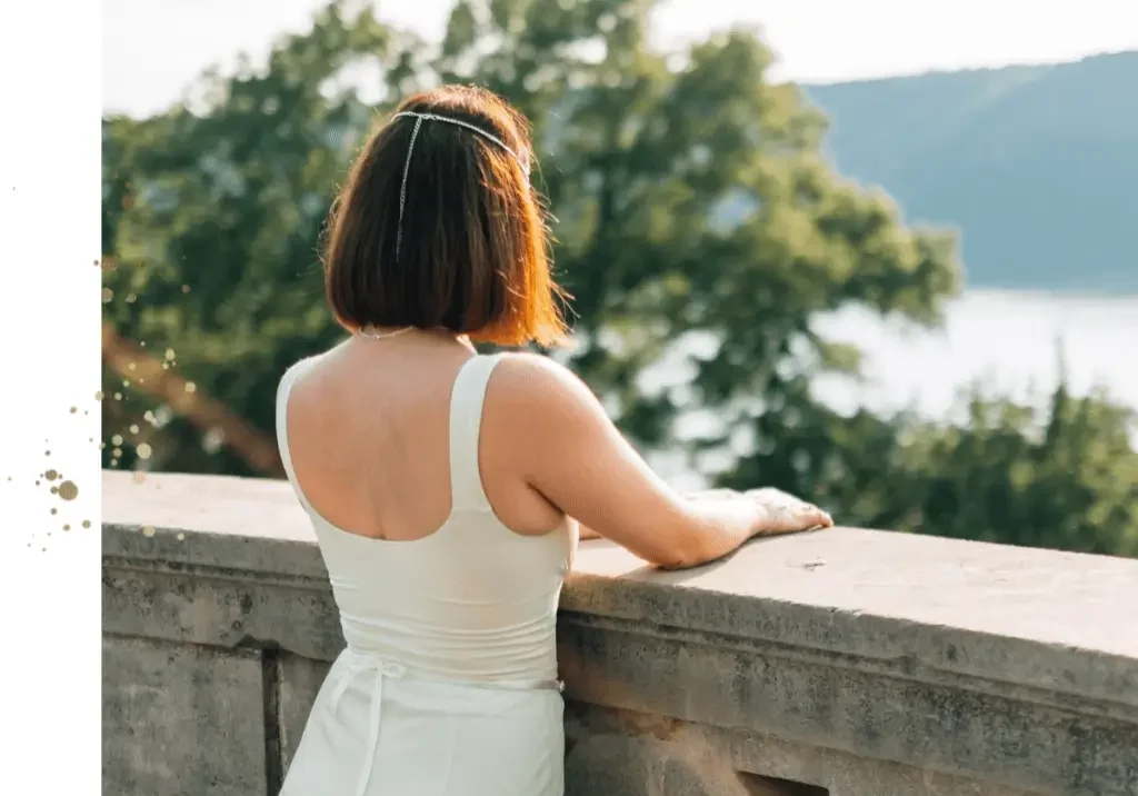 A woman wearing white dress standing at balcony